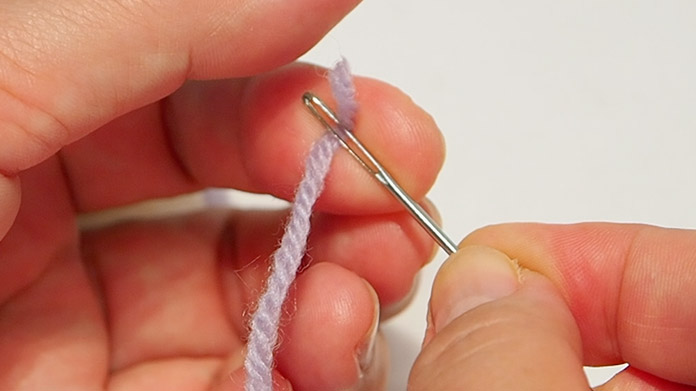 把羊毛的一端绕着针折成两半。