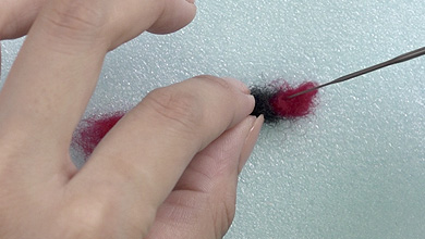 另一端用同样的方法拧红毛毡，然后用针扎。如果你还能看到电线，再加一些毛毡，然后戳一下。